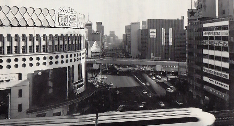 Nihon Gekijo Theater (commonly called Nichigeki) on the left in the foreground bears the “Toshiba” logo. The headquarters of Toshiba Engineering Co., Ltd. is in the Mazda Building on the right in the background.